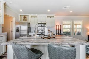 布罗肯鲍Lovely Broken Bow Cottage with Hot Tub and Fire Pit!的一个带2把酒吧椅的大岛厨房