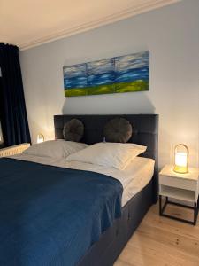 a bedroom with a bed with two paintings on the wall at Apartment Bellevue Bad Harzburg in Bad Harzburg +8 photos