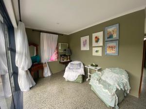 ClevedonHunua Hideaway的一间卧室，里面有一张床、一张桌子和一扇窗户