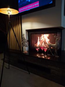a fireplace with glasses of wine in front of it at Cabana Ana in Borşa +29 photos
