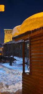a building with snow on the roof of it at Cottage Talu in Mestia in Mestia