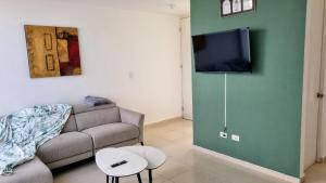 Jesús MaríaにあるHogar Augustaのソファと薄型テレビのあるリビングルーム