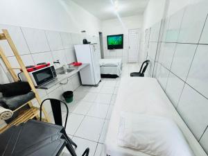 a small white room with a bed and a refrigerator at Ap no Derby com Garagem in Sobral