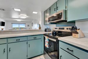 a kitchen with blue cabinets and a stove top oven at King's Hideaway in Daytona Beach Shores