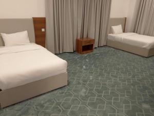 a hotel room with two beds and a room with at الوعل للشقق الفندقية بالارطاوية in Al Arţāwīyah