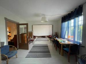 a living room with a table and chairs and a white curtain at Outintic House in Hästveda