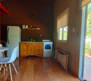 a kitchen with a white refrigerator and a table at Cabañas Panambi in Tigre