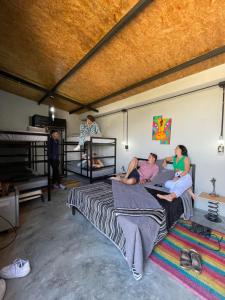 a group of people sitting on a bed in a room at Mambe refugio in Piedecuesta