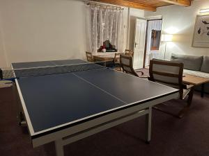 a ping pong table in a living room with chairs at Chata Slunečná louka in Cerny Dul