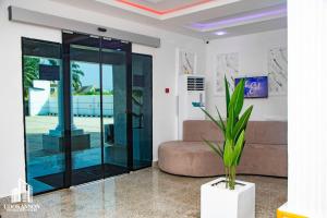 a glass elevator in a living room with a couch at Udokanson Hotel And Suites in Agbor