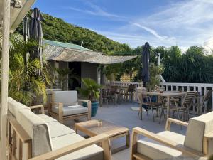 un patio al aire libre con mesas, sillas y una mesa en Koho SXM - ex Hevea Hotel, en Grand Case