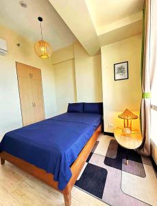 ein Schlafzimmer mit einem blauen Bett und einem Tisch in der Unterkunft SeaBu Properties in Lapu Lapu City + 8 Fotos