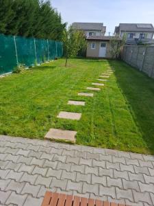 a backyard with a lawn with a stone pathway at Casa dulce casa in Dumbrăviţa