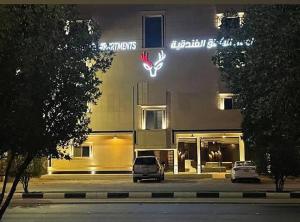 a car parked in front of a building at night at الوعل للشقق الفندقية بالارطاوية in Al Arţāwīyah