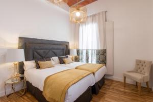 A bed or beds in a room at BiBo Suites Oro del Darro