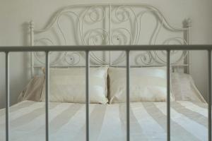 a white bed with white sheets and pillows at Vive Sanlúcar con aparcamiento en la puerta in Sanlúcar de Barrameda