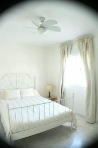 - une chambre avec un lit, un ventilateur de plafond et une fenêtre dans l'établissement Vive Sanlúcar con aparcamiento en la puerta, à Sanlúcar de Barrameda 6 autres photos