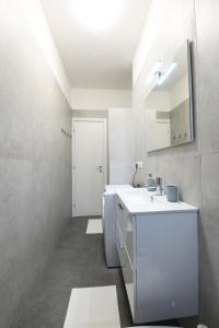 ミラノ-リスト	にあるNovegro Apartment Milano Linateの洗面台と鏡のある白いバスルーム