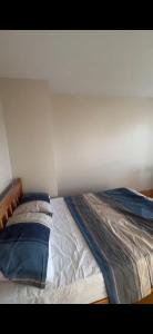 an unmade bed in a bedroom with a white wall at Church Bay House in Rathlin Island +6 photos