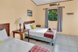 a hotel room with two beds and a window at Drift Inn Cayo in Santa Elena +59 photos