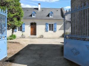 una grande casa bianca con un cancello davanti di Maison charmante à Bernac-Dessus avec jardin spacieux a Bernac-Dessus