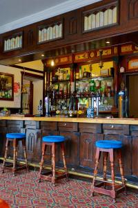 un bar con dos taburetes azules delante en The Midland, en Cheltenham