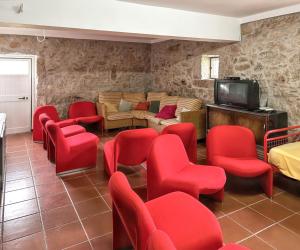 a waiting room with red chairs and a tv at Spacious house with mountain view in Vila Fernando in Vila Fernando