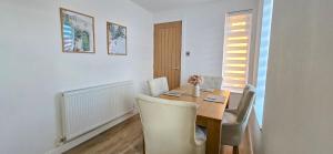 a dining room with a wooden table and chairs at Milton Keynes 3BR,Elegant Home, Sleeps 5, Families Stay, Free Parking in Milton Keynes
