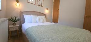 a bedroom with a bed with white sheets and pillows at Milton Keynes 3BR Stylish Home, Sleeps 5, Families Stay, Free Parking in Milton Keynes