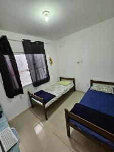 Un dormitorio con dos camas y una ventana. en Hostel Maravilha, en Palhoça