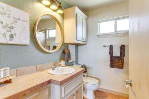 a bathroom with a sink and a mirror and a toilet at half Mi to Lake Lawtonka Mtn-View Haven! in Medicine Park +17 photos