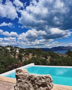 a blue swimming pool with a view of the water at Amos Sea View in Marmaris