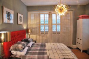 a bedroom with a bed with a red head board at Montpellier House in Milton Keynes