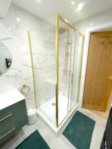 a shower with a glass door in a bathroom at Milton Keynes 3BR,Spacious Home, Sleeps 5, Families Stay, Free Parking in Milton Keynes