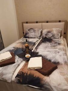 een bed met een dienblad met eten en een fles wijn bij Бутиков апартамент Kora DM in Stara Zagora +28 foto's