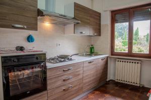 une cuisine avec des armoires en bois et un four à plaques de cuisson dans l'établissement Home Mate, à Ghivizzano