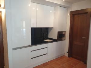 a kitchen with white cabinets and a brown door at Esencia Cazorla in Cazorla +9 photos
