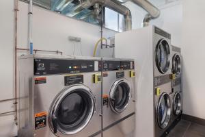 three washing machines are in a laundry room at Tequila Sunrise Podstel in Gold Coast