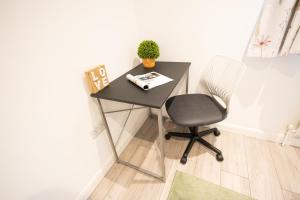 a black desk with a chair and a plant at Hardwick House in Banbury