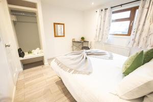 a bedroom with a white bed and a window at Hardwick House in Banbury