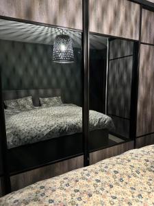 a bedroom with a bed and a large mirror at Modern apartement with parking in Kvaloysletta
