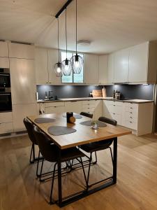 a kitchen with a wooden table and chairs at Modern apartement with parking in Kvaloysletta