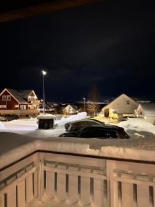 a parking lot covered in snow at night at Modern apartement with parking in Kvaloysletta