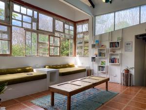 sala de estar con sofá, mesa y ventanas en ESO Santa Teresa, en Santa Teresa Beach