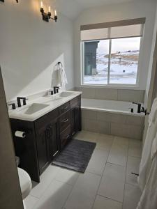 a bathroom with a sink and a tub and a window at Sky Sapphire Haven in Fish Haven +33 photos