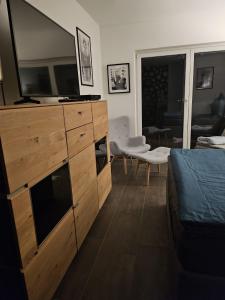 a bedroom with a dresser with a television on it at Ferienwohnung AM HOCHBERG in Bad Kissingen