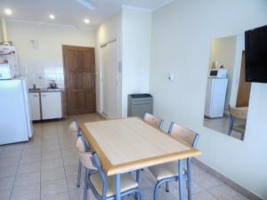 cocina y comedor con mesa y sillas en Apartamentos Güemes - Monoambientes en Bahía Blanca