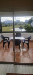 a patio with a table and chairs and a view of a golf course at Golf & sea view appartement in Marina golf Asilah in Asilah
