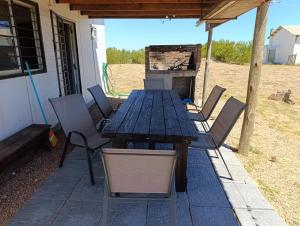 une table et des chaises en bois sur une terrasse dans l'établissement Casa a 50 metros de la playa PuntaNegra, à Punta Colorada