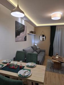 Apartman Silvija 2 Divčibare في ديفشيبار: غرفة معيشة مع أريكة وطاولة